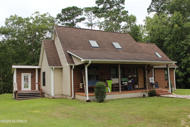 back of property with a shingled roof, a porch, and a lawn