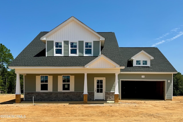 craftsman inspired home with stone siding, roof with shingles, and an attached garage