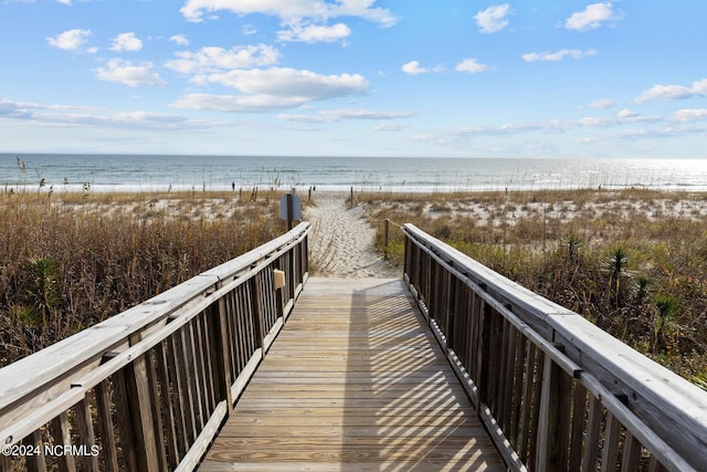 view of home's community with a water view and a beach view