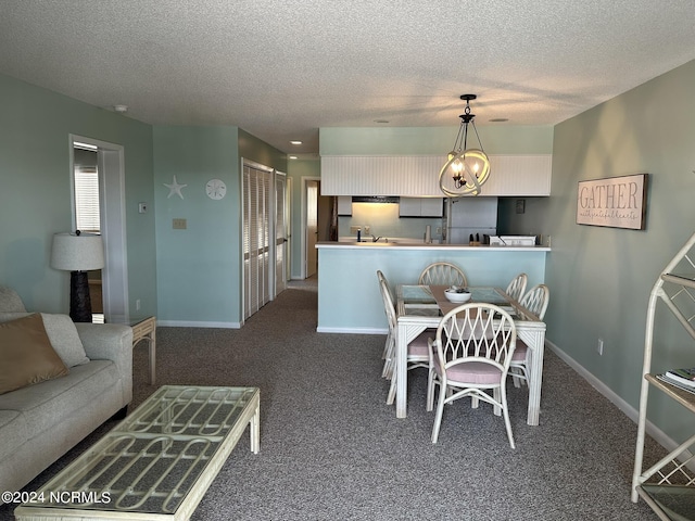 dining space featuring a notable chandelier, a textured ceiling, dark carpet, and baseboards