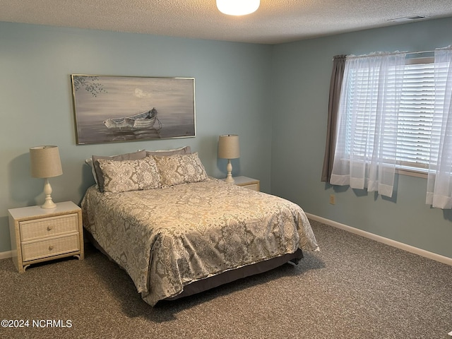 bedroom featuring visible vents, carpet flooring, a textured ceiling, and baseboards