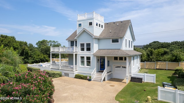 view of front of house with a balcony, a garage, and a front lawn