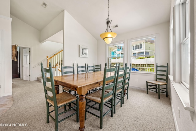 dining room featuring vaulted ceiling, stairway, visible vents, and light colored carpet