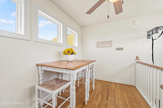 dining space featuring a ceiling fan, baseboards, visible vents, and light wood finished floors