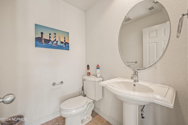 half bath with toilet and baseboards