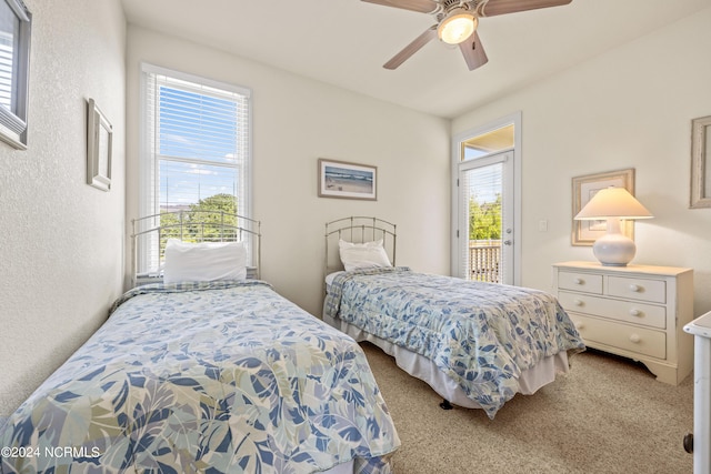 carpeted bedroom featuring access to exterior, a textured wall, and a ceiling fan