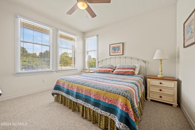 carpeted bedroom with ceiling fan, multiple windows, and baseboards