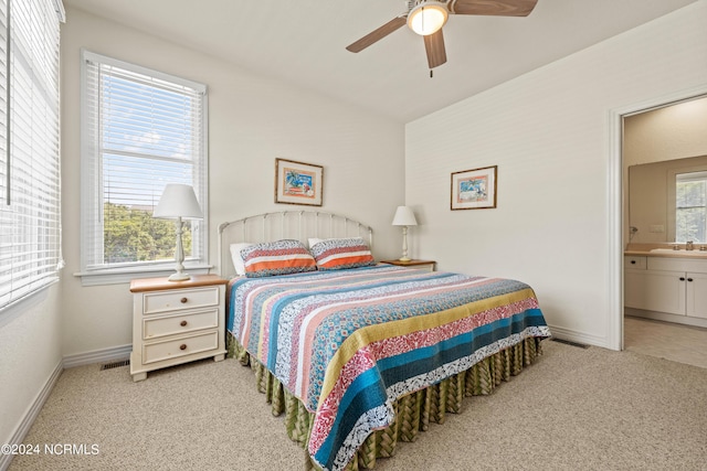 carpeted bedroom featuring baseboards, visible vents, and a sink