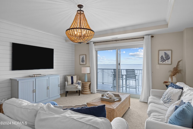 living room featuring a water view, light colored carpet, a chandelier, and crown molding