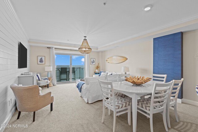 carpeted dining area featuring an inviting chandelier and ornamental molding