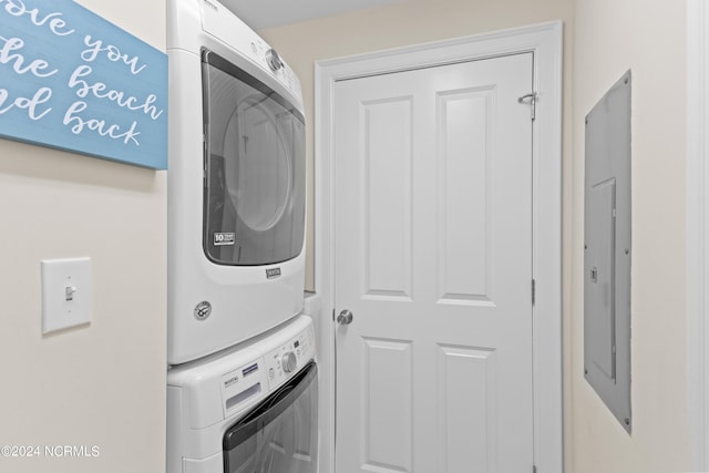 washroom featuring laundry area, electric panel, and stacked washer and clothes dryer