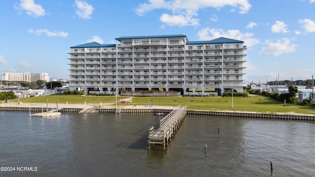 view of dock featuring a water view and a yard