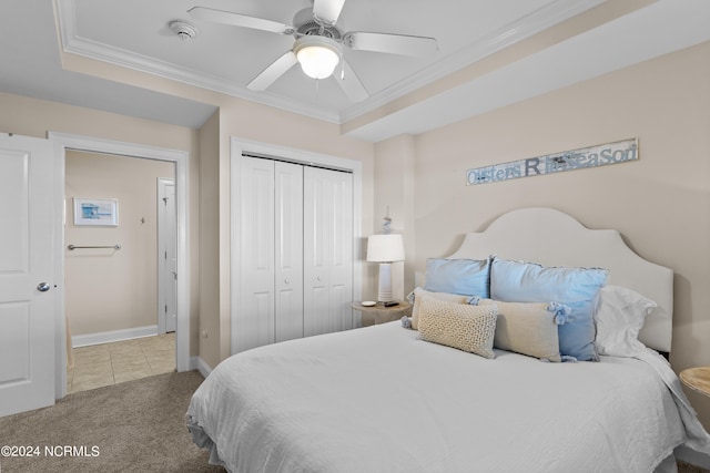 bedroom with crown molding, carpet flooring, ceiling fan, and a closet