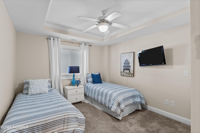 carpeted bedroom with ceiling fan, baseboards, ornamental molding, and a raised ceiling