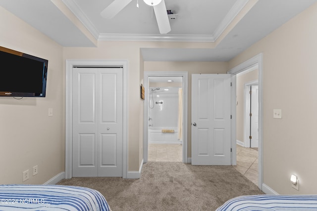 carpeted bedroom with ornamental molding, a raised ceiling, ceiling fan, and a closet