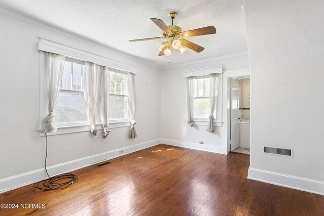 unfurnished room with a wealth of natural light, ceiling fan, and dark wood-type flooring