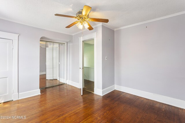 unfurnished bedroom featuring a textured ceiling, ceiling fan, ornamental molding, and wood-type flooring