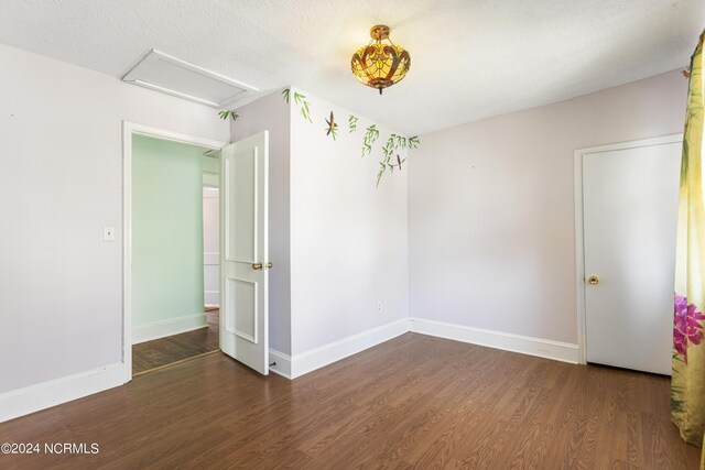 empty room featuring a textured ceiling and wood-type flooring