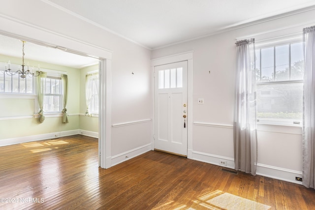 foyer entrance with a notable chandelier, hardwood / wood-style floors, a wealth of natural light, and baseboards