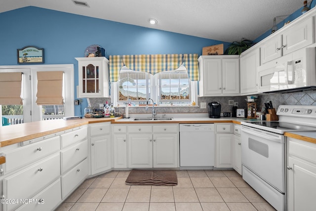 kitchen featuring white appliances, sink, white cabinets, and lofted ceiling