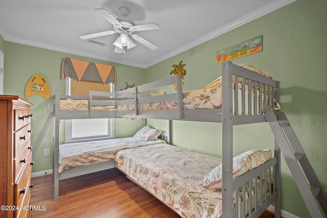 bedroom with a textured ceiling, ceiling fan, ornamental molding, and hardwood / wood-style flooring