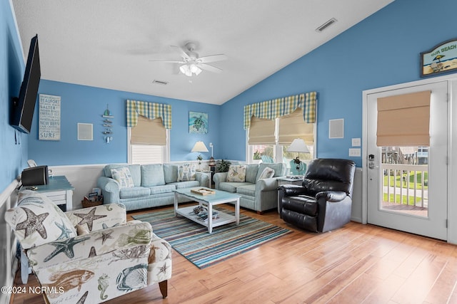 living room with lofted ceiling, hardwood / wood-style floors, and ceiling fan