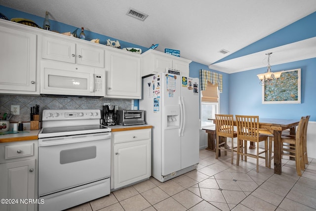 kitchen featuring vaulted ceiling, decorative light fixtures, white appliances, a chandelier, and white cabinets