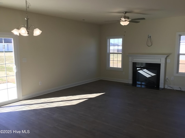 unfurnished living room featuring dark hardwood / wood-style floors and ceiling fan with notable chandelier