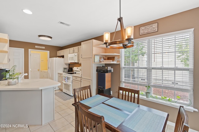 tiled dining space featuring a wealth of natural light, sink, and an inviting chandelier