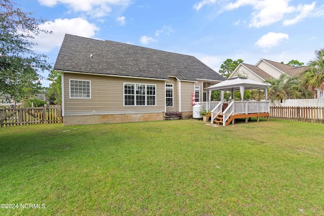 rear view of property featuring a gazebo, a yard, and a wooden deck