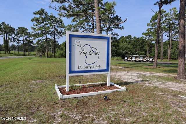 community / neighborhood sign featuring a lawn