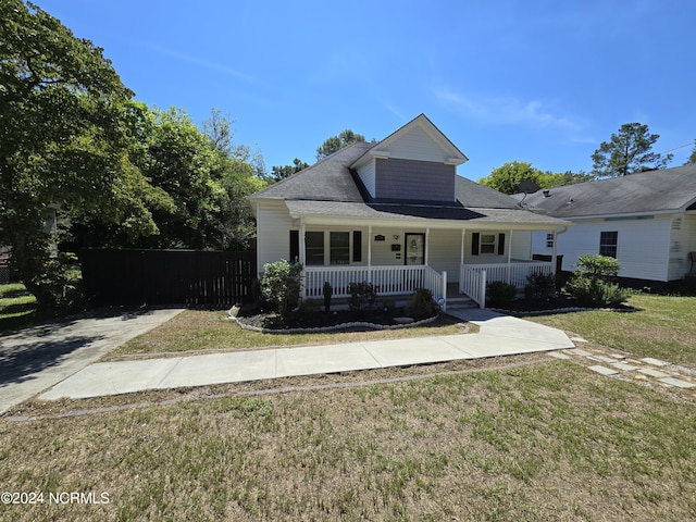 view of front facade featuring fence, a front lawn, and a porch