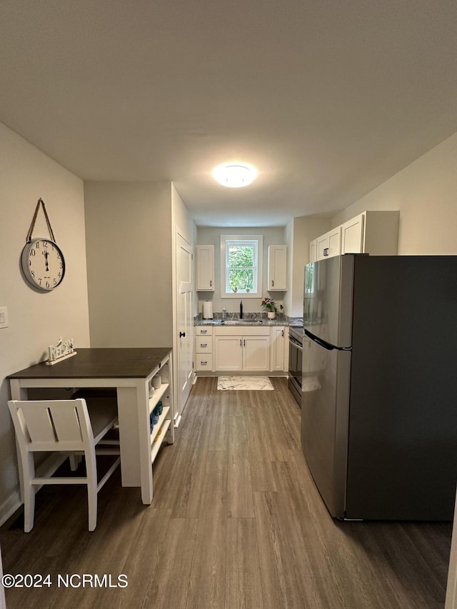 kitchen featuring stainless steel appliances, dark wood-type flooring, a sink, and white cabinetry