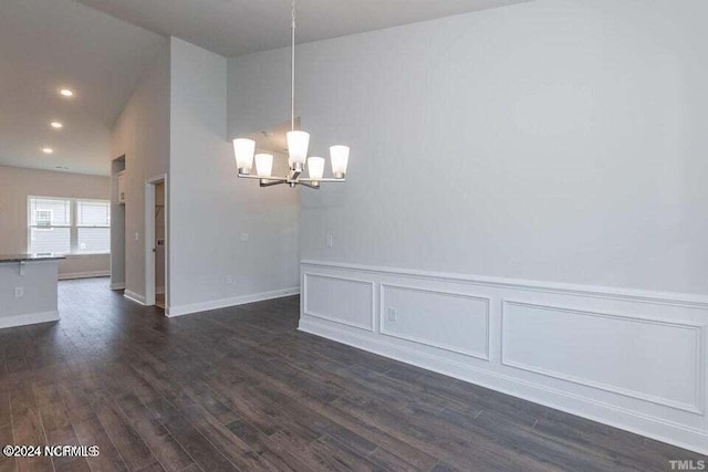 unfurnished dining area featuring an inviting chandelier and dark hardwood / wood-style floors