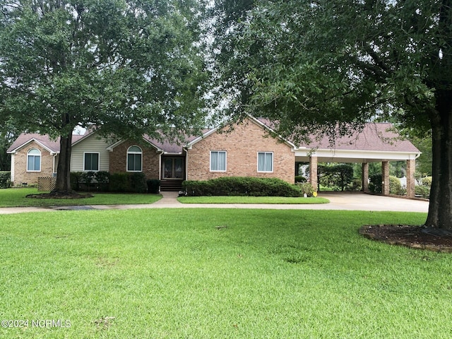 ranch-style home with concrete driveway, a carport, brick siding, and a front yard