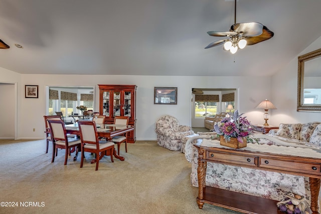 interior space with light carpet, vaulted ceiling, and a healthy amount of sunlight