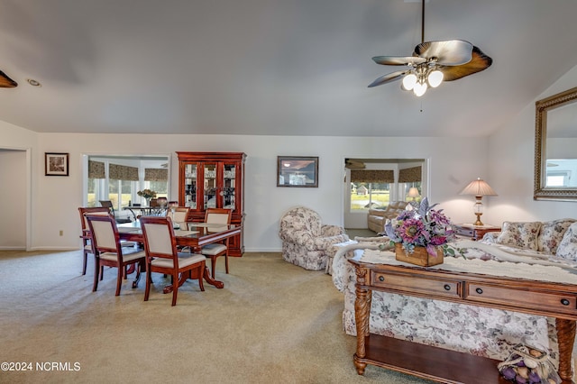 carpeted dining space featuring lofted ceiling, ceiling fan, and baseboards