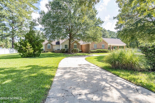 view of front of home featuring fence, a front lawn, concrete driveway, and brick siding