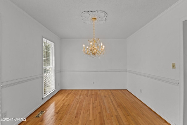 unfurnished dining area featuring plenty of natural light, a notable chandelier, and light wood-type flooring