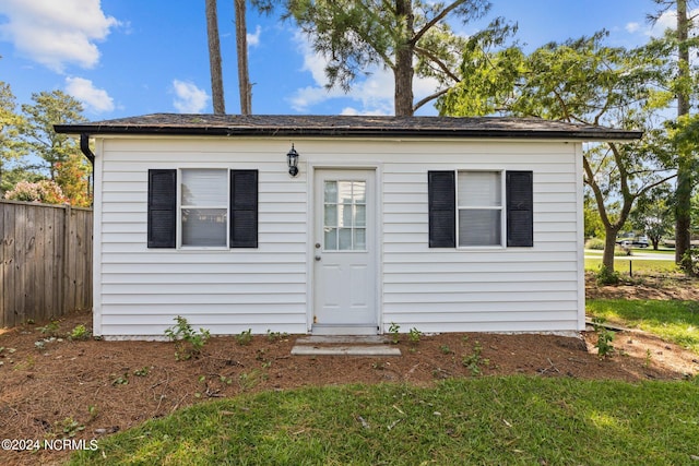 bungalow-style home with an outbuilding and fence