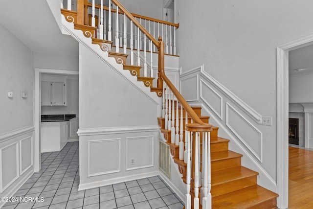 stairway with a fireplace and hardwood / wood-style flooring