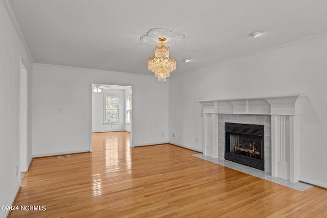 unfurnished living room featuring crown molding, light hardwood / wood-style flooring, and a tiled fireplace