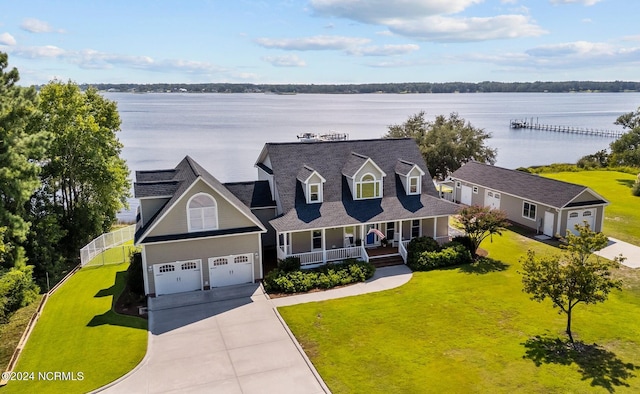 exterior space featuring a garage, a porch, a water view, and a front yard