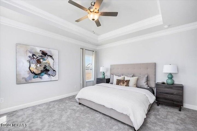 carpeted bedroom with ornamental molding, a raised ceiling, ceiling fan, and baseboards