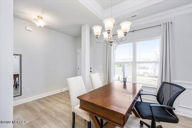 dining space featuring ornamental molding, light wood-style flooring, baseboards, and an inviting chandelier