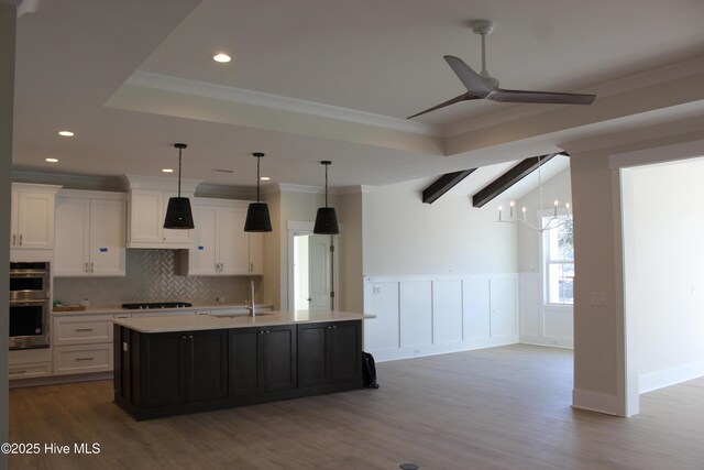 interior space featuring a tray ceiling, a notable chandelier, crown molding, and dark wood-type flooring