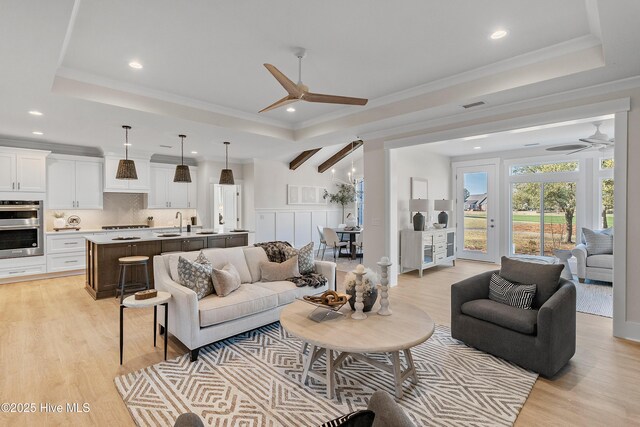 9307 Old Salem Way, Calabash, NC 28467 - living area with ceiling fan, light wood finished floors, recessed lighting, a tray ceiling, and ornamental molding