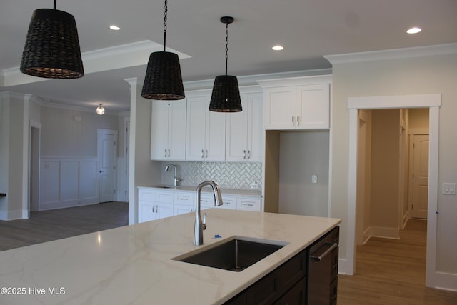 kitchen featuring dark wood-type flooring, sink, light stone counters, crown molding, and white cabinets