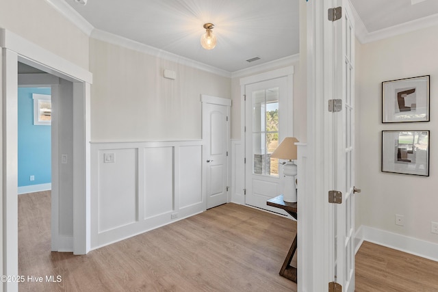 9307 Old Salem Way, Calabash, NC 28467 - foyer featuring light wood-style flooring, crown molding, a wainscoted wall, and a decorative wall