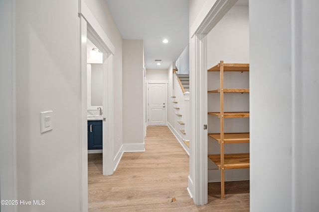 9307 Old Salem Way, Calabash, NC 28467 - hall featuring stairway, light wood-style flooring, baseboards, recessed lighting, and a sink